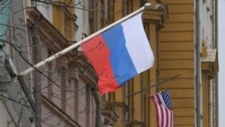 Российский флаг на фоне флага на посольстве США в Москве. Апрель 2021 года.